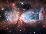 Nebeský anděl. Sharpless 2-106 se nachází ve vzdálenosti 2000 světelných let. Jedná se o mlhovinu, ve které vznikají nové hvězdy. Modrou barvou je znázorněn velmi horký plyn, za tvar může hvězda IRS 4. Credit: NASA, ESA